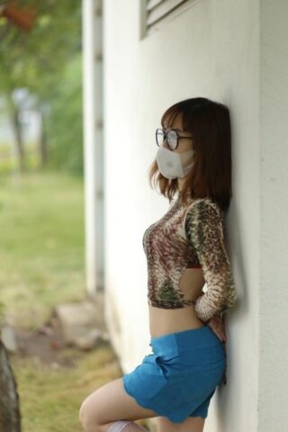 Asian brunette babe with a mask & glasses poses in her sexy outfit